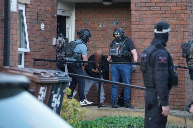 Man led out in handcuffs during counter-terrorism raid