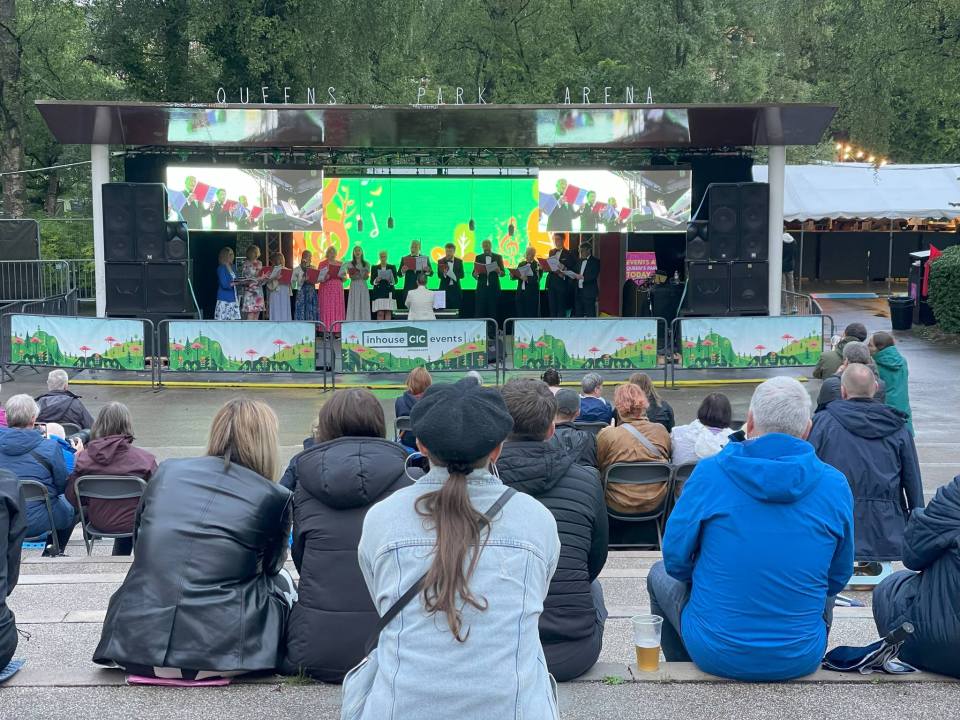 Choir performing on stage in front of an audience.