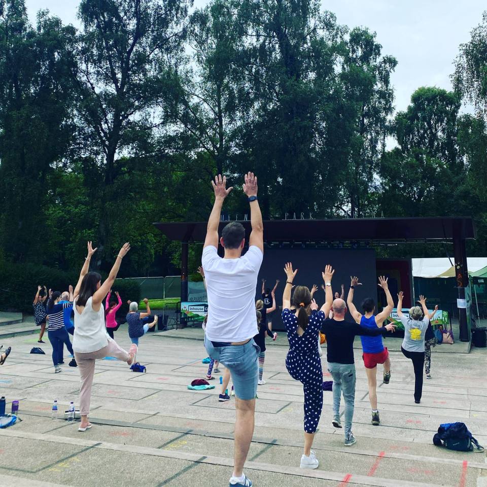Group of people doing yoga outdoors.