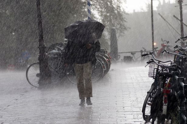 Man with umbrella in severe rain