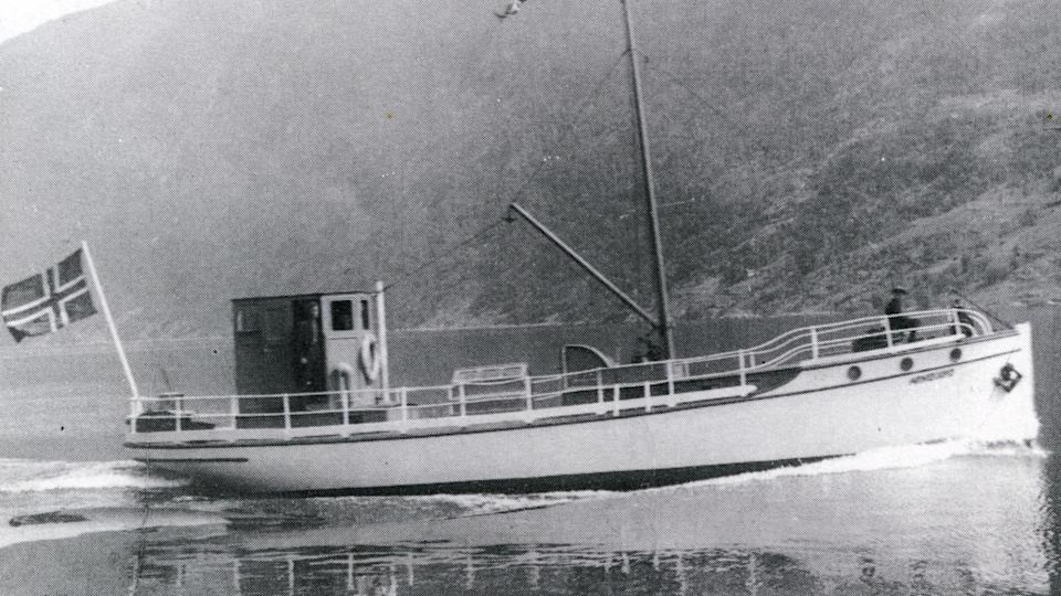 An old pic of a fishing boat in black and white. It appears to have a Norwegian flag waving on its back end 