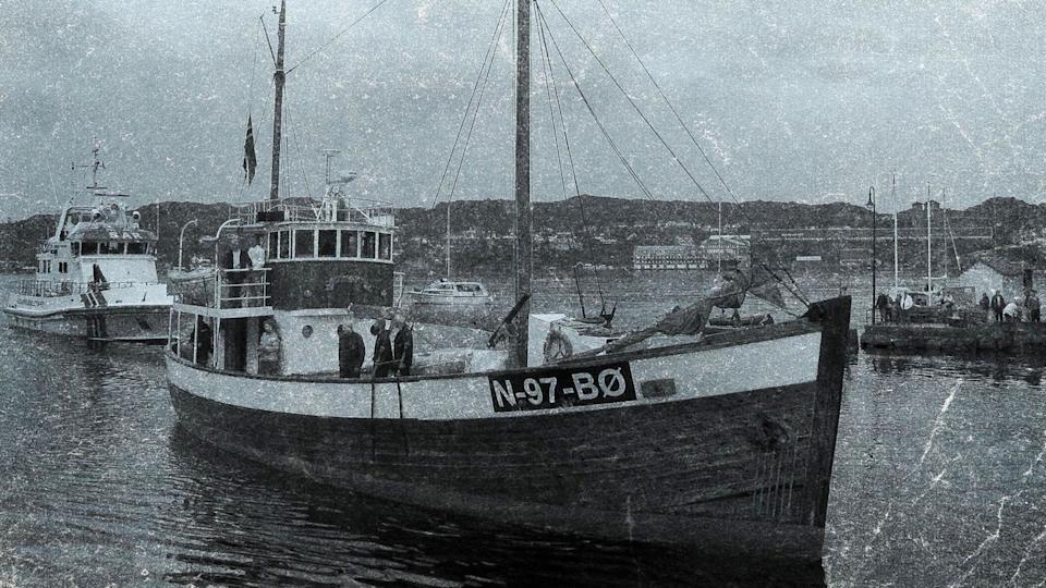 A black and white picture of a sailing boat called the M/K Andholmen. It has N-97-BO written on the side and other boats can be seen behind it 