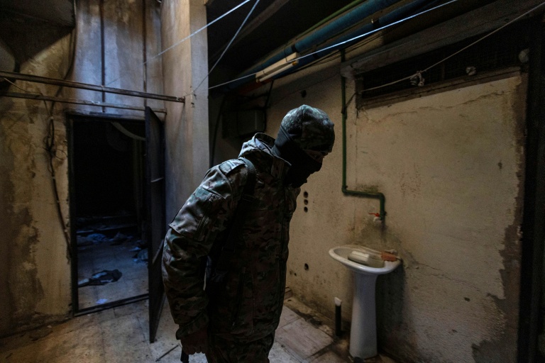 A rebel fighter inspects a room in the Syrian General Intelligence Directorate Branch 251, also known as Al-Khatib branch, in the capital Damascus on December 25, 2024 (Sameer Al-DOUMY)