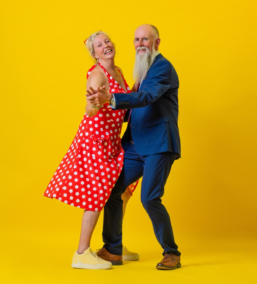 Senior couple dancing joyfully against a yellow background.