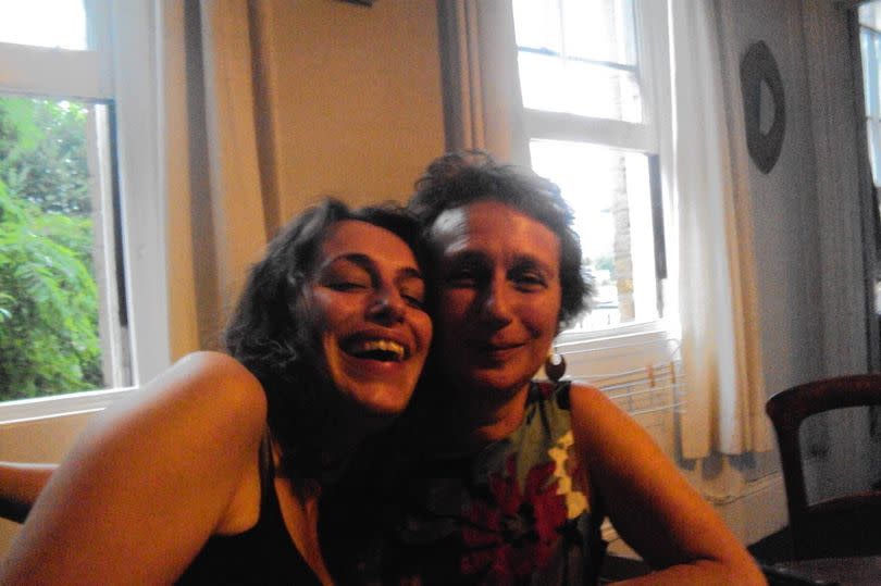 Anna and her mother sitting close together to take a photo