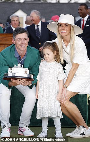 Rory McIlroy of Northern poses with his wife Erica Stoll and daughter Poppy when he receives his Green Jacket after winning the 2025 Masters Tournament in Augusta, Georgia