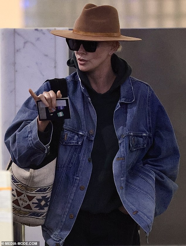 She also cut quite the casual figure for her flight, rugging up with a blue denim jacket over a black hooded jumper