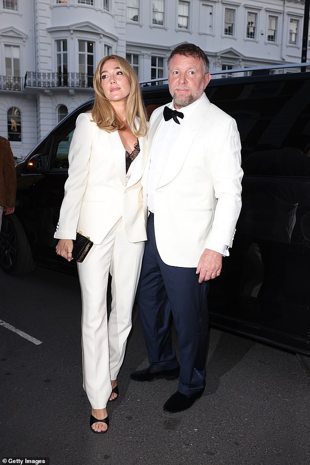 Jacqui looked typically chic in a white suit, with a black lace bra underneath and teamed with platform heels