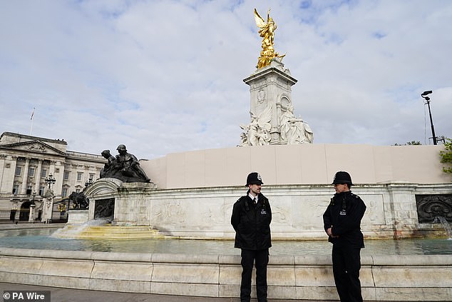 Police officers by the Queen Victoria Memorial ahead of commemorations this afternoon
