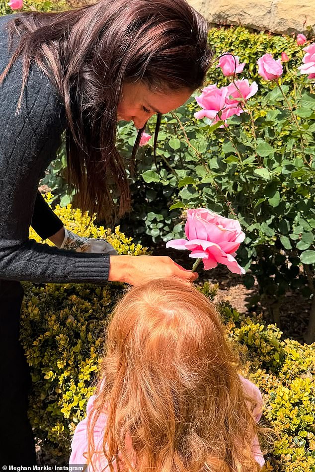 Lilibet's bright red hair was visible in the adorable snapshots shared by Meghan, showing the pair picking summer roses in the garden
