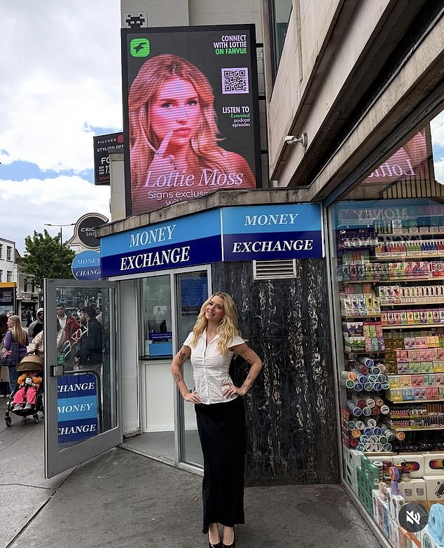 Lottie Moss has shared this photograph online of her posing beneath a billboard displaying her image in an advertisement for Fanvue