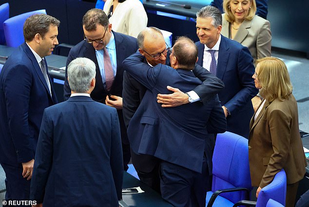 Germany's Chancellor Friedrich Merz is congratulated as he is elected chancellor by parliament in second round of voting in the German lower house of parliament Bundestag