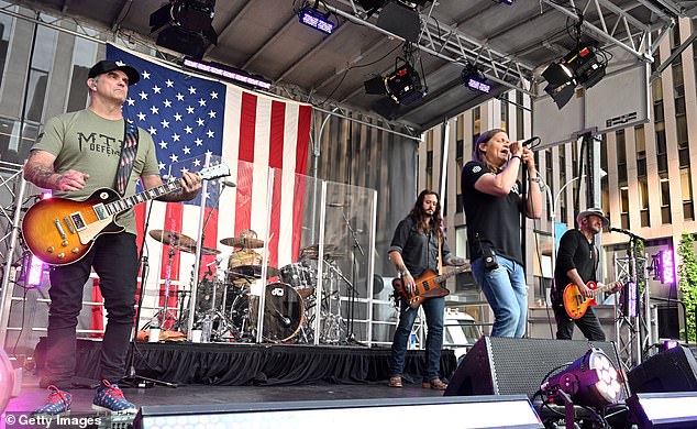Arnold is pictured performing with the band including Chris Henderson, Greg Upchurch, Justin Biltonen, Brad Arnold and Chet Roberts