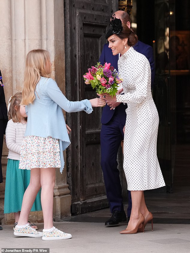 A young girl handed Kate with the bouquet before she laid them down at the Innocent Victims' Memorial