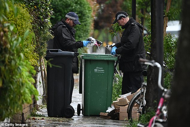 Police officers were pictured looking through rubbish bins for any potential evidence -- May 12, 2025