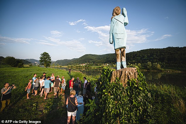 People gather around what conceptual artist Ales 'Maxi' Zupevc claims is the first ever monument of Melania Trump, set in the fields near the town of Sevnica, US First Lady's hometown, during a small inauguration celebration on July 5, 2019