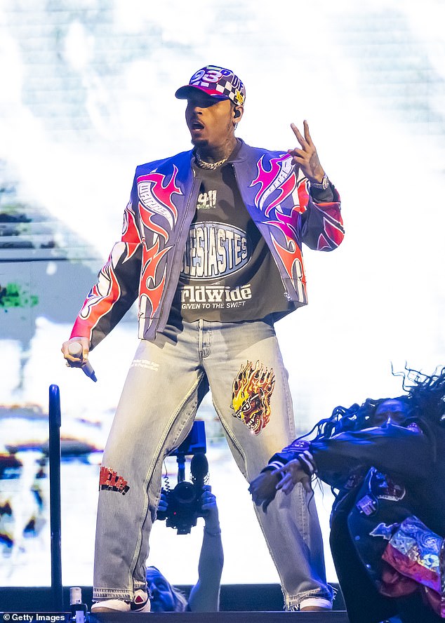 At Manchester Magistrates' Court yesterday, Brown was flanked by two security guards in the dock after he walked in shortly before 1pm and was wearing black Nike tracksuit bottoms and a plain black T-shirt. Pictured: Brown performs at Little Caesars Arena in Detroit