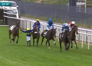 A jockey went 'horse skating' as he clung into two horses after being thrown from his own