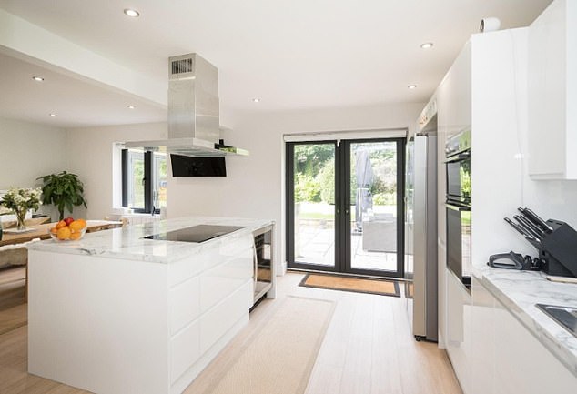 The kitchen features large glass doors to look out to the spacious garden area