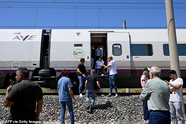 People get off a stopped high-speed AVE train near Cordoba on April 28