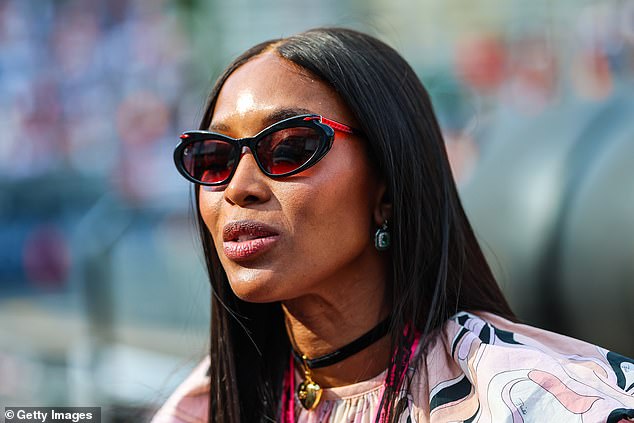 Naomi polished her outfit with a pair of black sunglasses, a host of beaded bracelets plus a black chocker with a statement heart shaped pendant