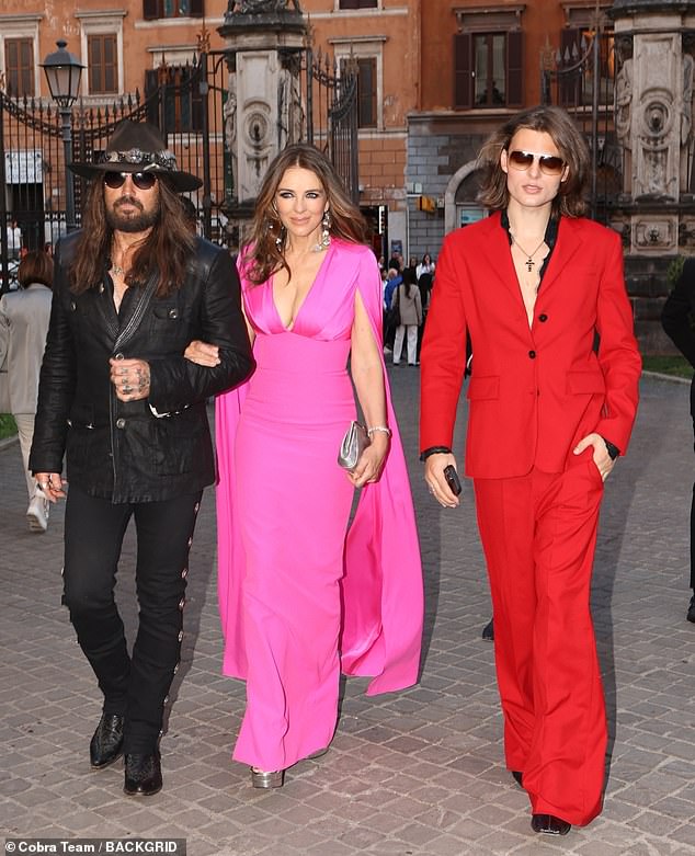 The lovebirds were supported on their first public outing by Elizabeth's lookalike son Damian (R) who was also dressed to impress