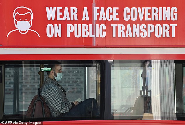 A man travels on a bus wearing a face mask in central London on June 16, 2020