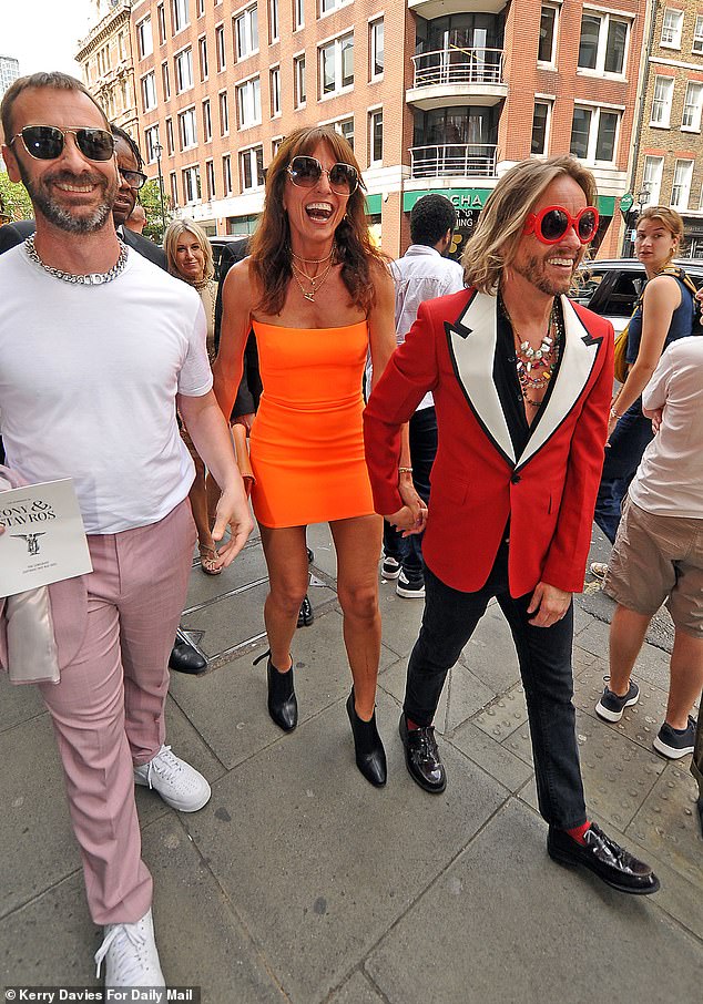 The TV presenter turned heads in a bright orange mini dress and black ankle boots