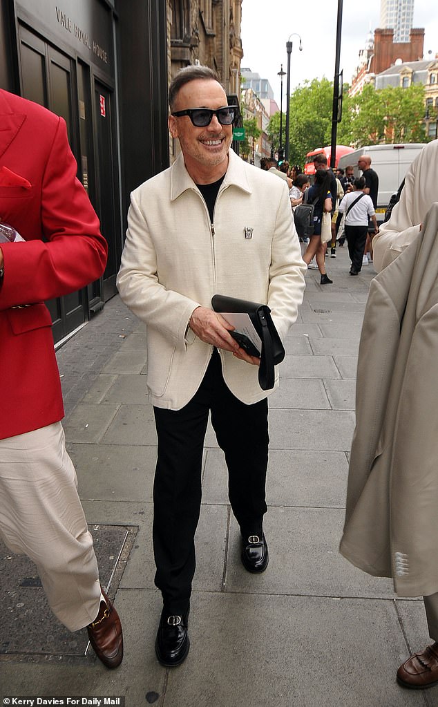 Elton John's husband David Furnish looked dapper in a cream jacket and black trousers with matching shoes