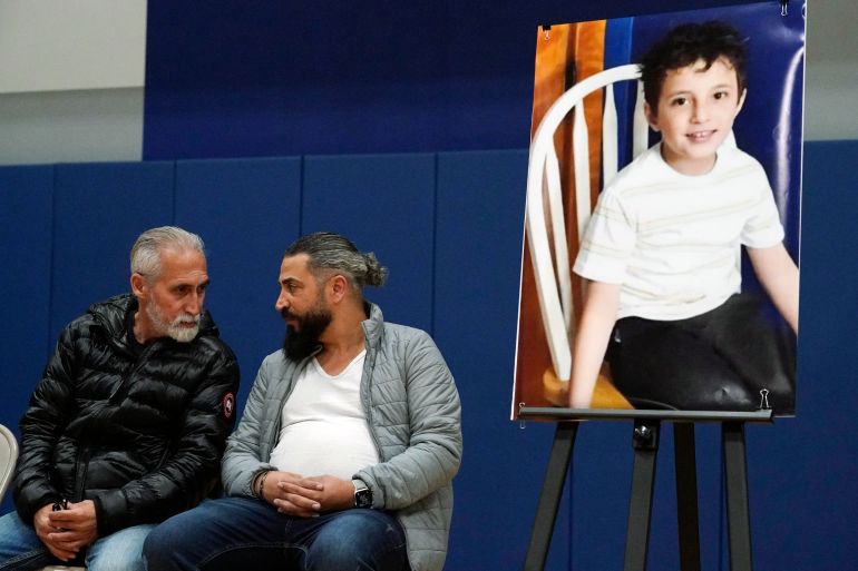 Oday Al Fayoume sits beneath a portrait of his slain 6-year-old son.