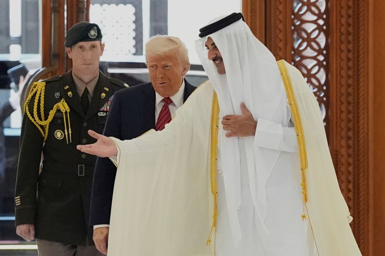 Emir Sheikh Tamim bin Hamad Al Thani gestures as he greets Donald Trump