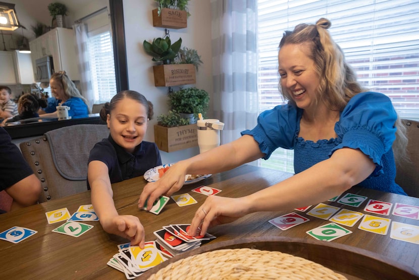 (From left) Marley Mansour, 11, and mother Kayla Mansour play Uno at their home in Rowlett...