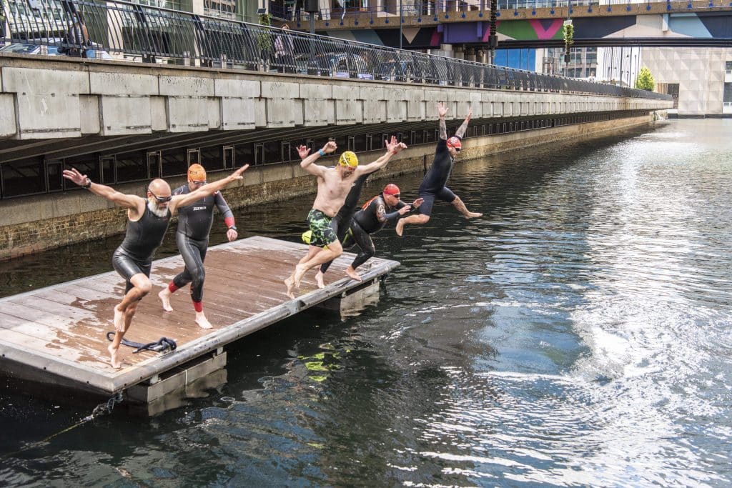 Swimmers at Canary Wharf jumping in