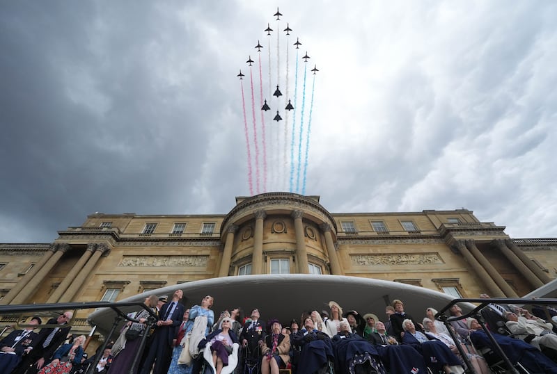 Onlookers watch the flypast at Buckingham Palace. Photograph: Yui Mok - WPA Pool/Getty Images