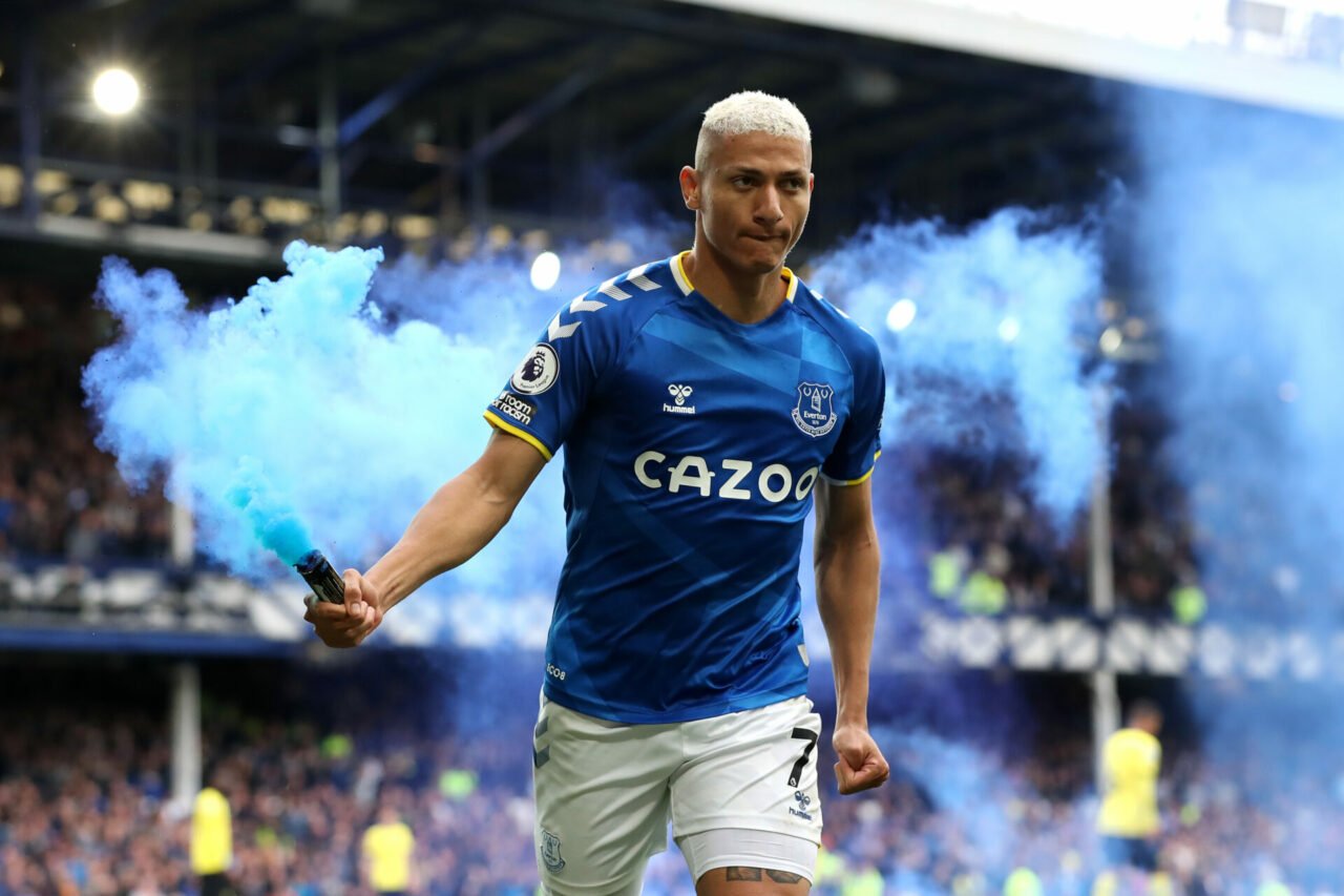 Richarlison of Everton celebrates with a flare after scoring their team's first goal during the Premier League match between Everton and Chelsea at...