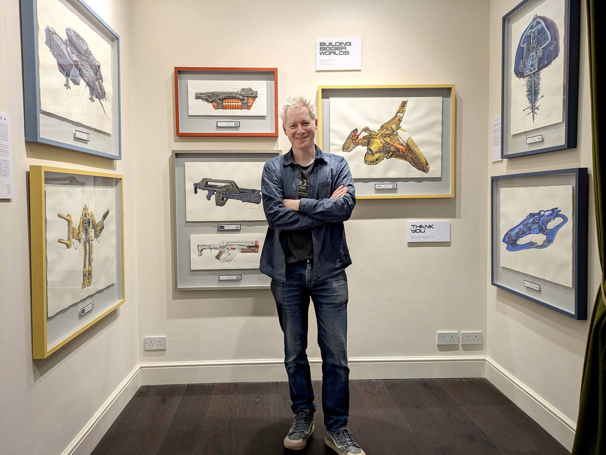 artist john r mullaney stood in front of sci-fi artworks at his exhibition