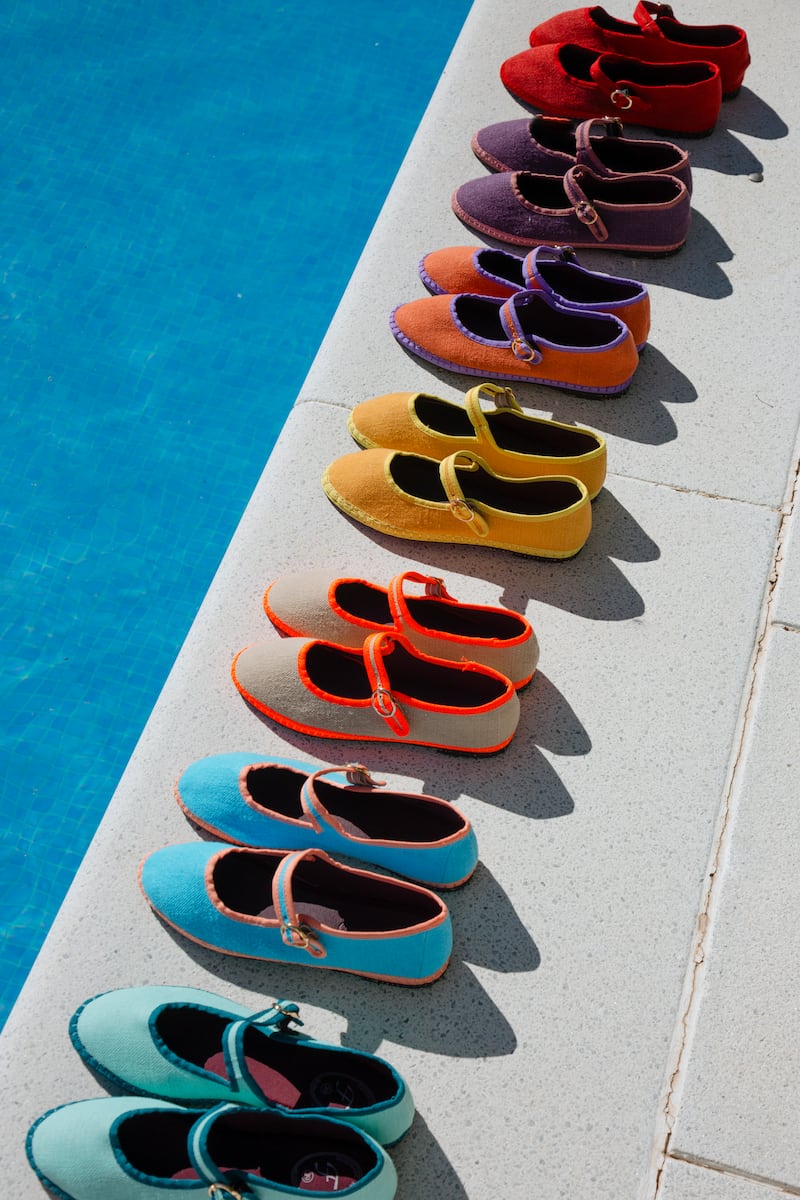 A lineup of colourful Flabelus shoes by a pool.