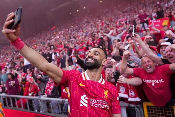 Liverpool's Mohammed Salah celebrates by taking a selfie after winning the English Premier League match between Liverpool and Tottenham Hotspur and cl