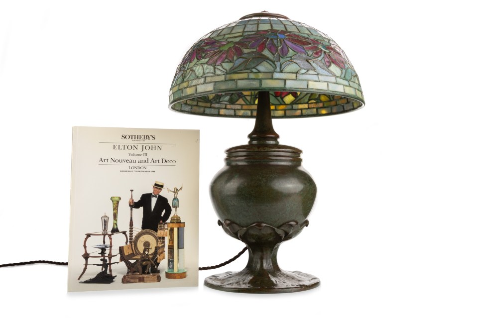Table lamp with stained glass shade and a book about Elton John's Art Nouveau and Art Deco collection.