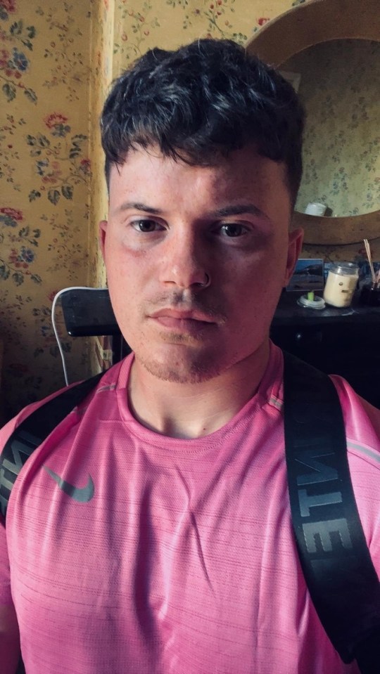 Close-up portrait of a young man wearing a pink Nike shirt.