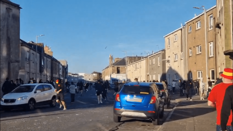 A crowd of people walking down a residential street.