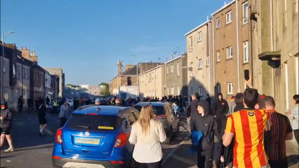 Large group of people gathered on a residential street.