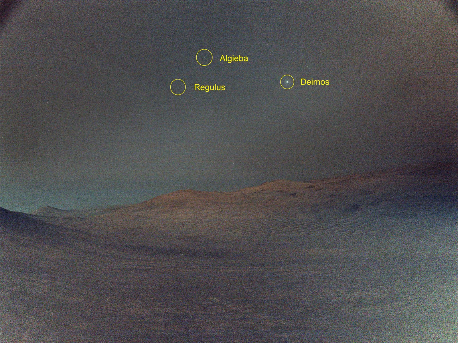 A Martian landscape under a dusky sky with three labeled celestial objects: Algieba, Regulus, and Deimos. The surface appears rocky and barren, with gentle hills on the horizon.