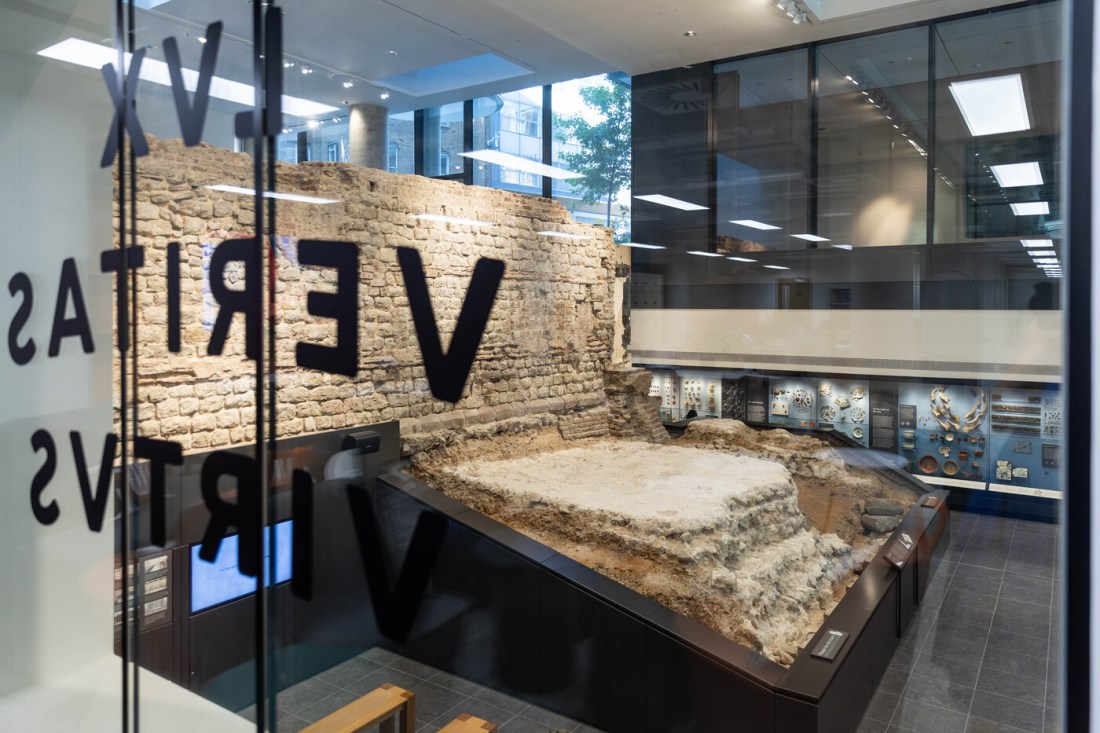 A piece of a Roman wall behind glass in a building in Northeastern's London campus.