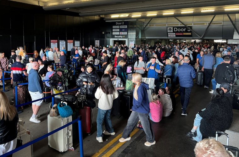 Passengers queue outside Terminal 1 after an overnight power cut led to disruptions and cancellations at Manchester Airport in Manchester, Britain, June 23, 2024. REUTERS/Phil Noble