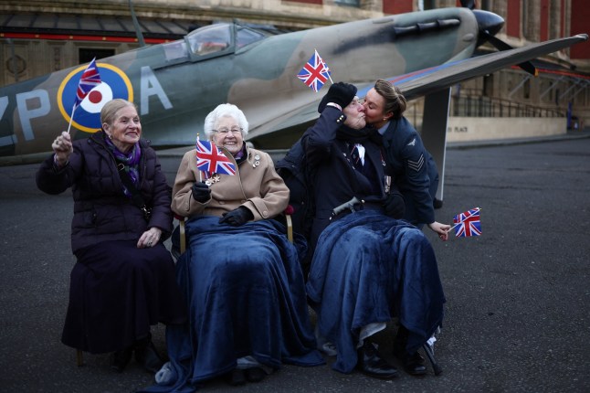 TOPSHOT - (Front row from L) Doreen Simson, 87 years old, who was a child evacuee from London, former Wren Ruth Barnwell, 100 years old, veteran Henry Rice, 98 year old, and D-Day Darlings lead vocalist Katie Ashby pose in front of full size replica Spitfire during a photo call organised by SSAFA, UK's oldest Armed Forces charity, to launch the 80 day countdown for the VE (Victory in Europe) Day "VE Day 80: The Party", outside Royal Albert Hall, in London, on February 17, 2025. The 80th anniversary of the official end of World War II in Europe in the Eastern Front, will be celebrated with the event "VE Day 80: The Party", on May 8, 2025 at the Royal Albert Hall. (Photo by HENRY NICHOLLS / AFP) (Photo by HENRY NICHOLLS/AFP via Getty Images)
