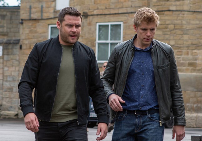 Aaron and Robert walking through Emmerdale