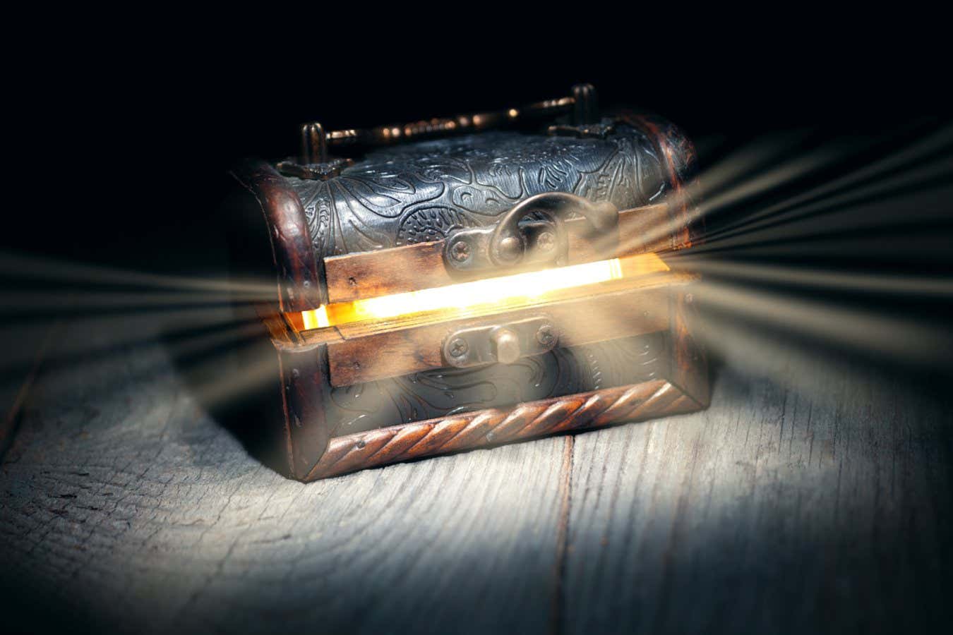 Glowing bright rays of light from an old, open wooden dark brown treasure chest, the concept of a surprise, gift, pandora