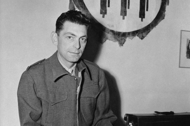 Edward Kennedy of the Associated Press Cairo staff, poses with airplane insignia on wall, picked up from Italian transport wrecked in desert, March 8, 1943. (AP Photo)