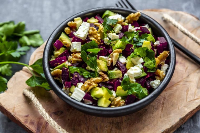 Bowl of beetroot salad with avocado, feta, walnuts and parsley